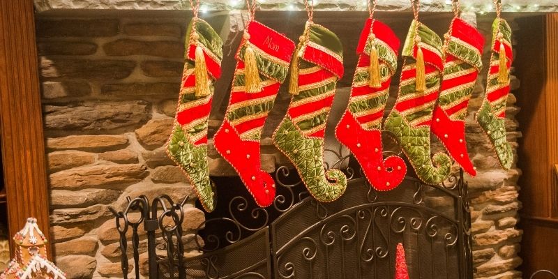 https://momlifehappylife.com/wp-content/uploads/2021/09/toddler-stocking-stuffer-ideas-stockings-lined-up-on-stone-fireplace.jpg